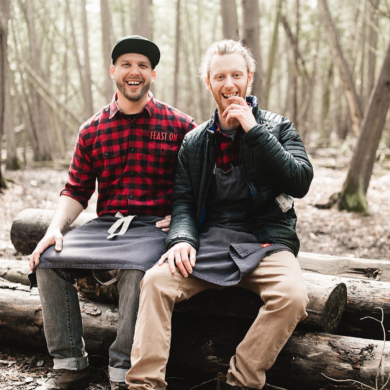 Eric and Sam, the chefs from sixthirtynine sitting on logs in the woods at terroir event