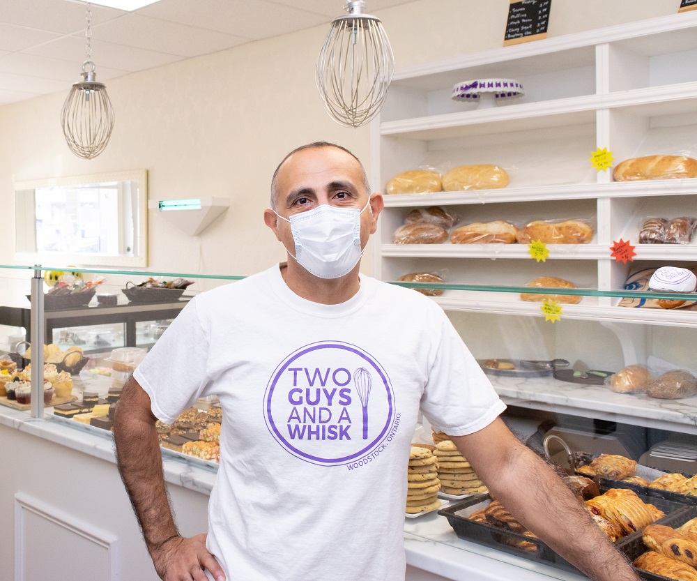 nabil standing in front of baked goods at two guys and a whisk